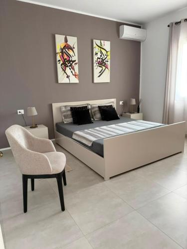 a bedroom with a large bed and a chair at NYC trifft auf Top Moderne Wohnung in Hergla in Harqalah