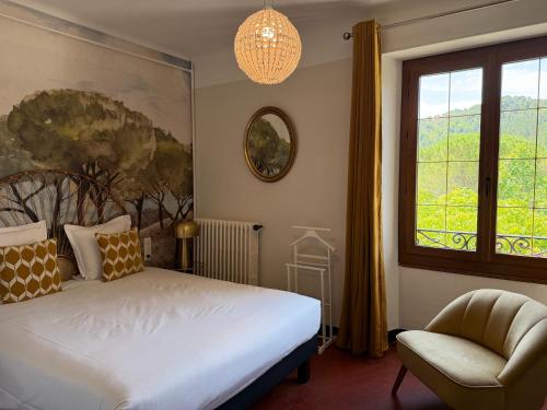 a bedroom with a bed and a window and a chair at Hôtel du Moulin in Allemagne-en-Provence