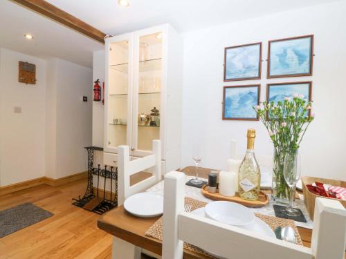 a kitchen and dining room with a table and chairs and a window at Ty Loti in Caernarfon