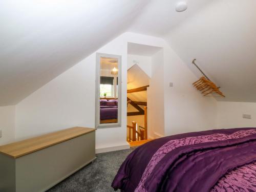 a bedroom with a bed and a mirror at Ty Loti in Caernarfon