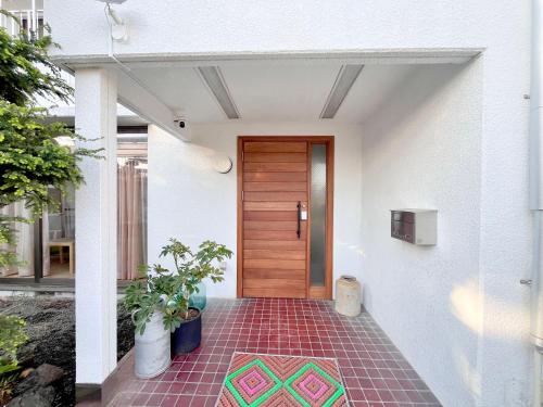 a front door of a house with a tile floor at BRICKS and BLOCKS MIYOTA in Miyota