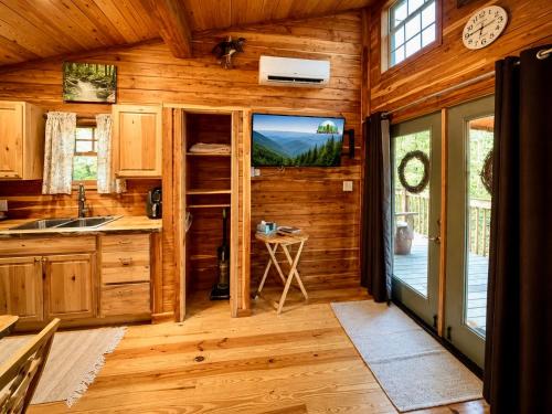 a kitchen in a log cabin with a large window at Treehouse by the Creek in Walland