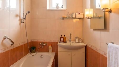 a bathroom with a bath tub and a sink at Villasobota in Rimavská Sobota