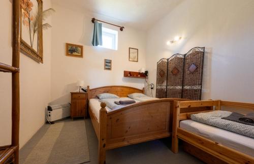 a bedroom with two beds and a window at Tisza-tavi Kiserdő Vendégház in Tiszaderzs