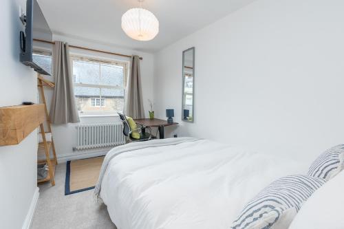 a white bedroom with a bed and a window at Regent Street Residence Lutterworth in Lutterworth