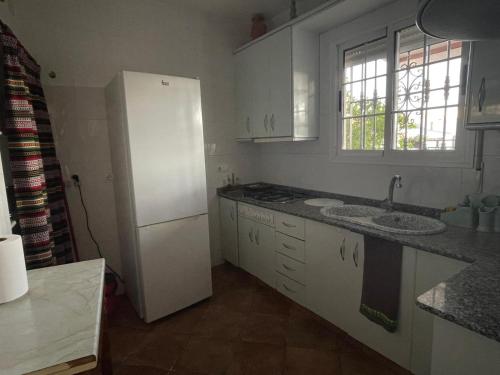 a kitchen with a white refrigerator and a sink at Las cuevas de María in Bácor
