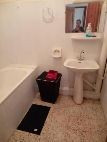 a bathroom with a sink and a tub and a mirror at Résidence EPLF SAKET BÉJAÏA in Bejaïa