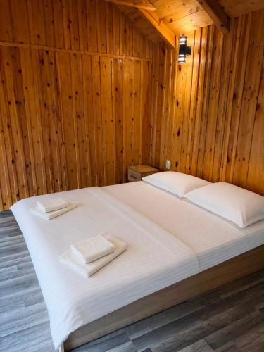 a bed in a wooden room with two towels on it at Hellena in Sarajevo