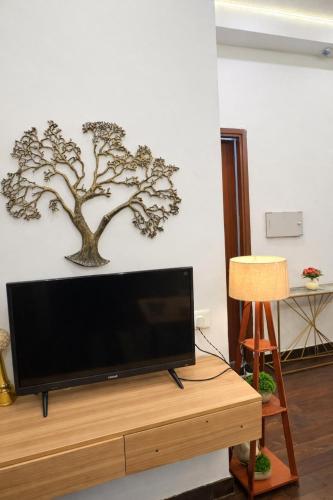 a flat screen tv sitting on top of a wooden table at Glory Stays in Noida