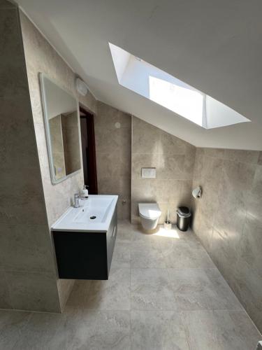 a bathroom with a sink and a toilet and a skylight at Mam in Vir