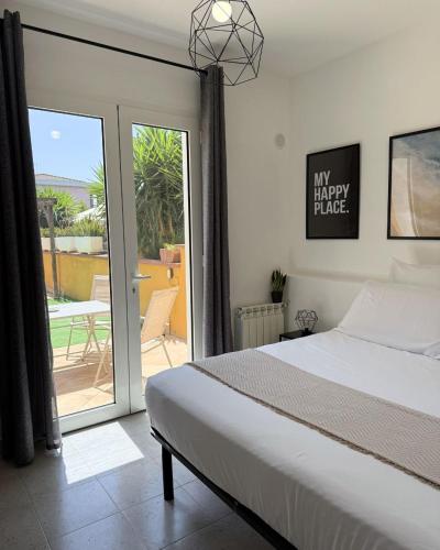 a bedroom with a bed and a view of a patio at Maya Apartments in La Maddalena