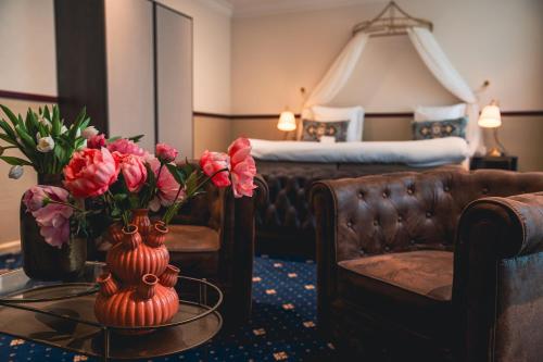 a hotel room with a vase of flowers on a table at Boutique Hotel De Doelen in Groningen