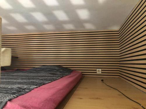 a bed in a room with a wooden wall at à pied dans l eau écolo 97434 in L'Ermitage-Les-Bains