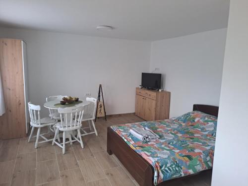 a bedroom with a bed and a table and chairs at Perucac Apartman in Perućac