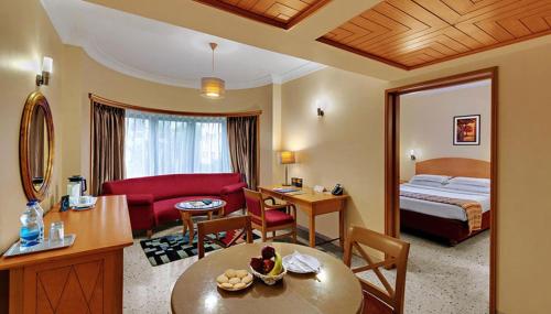 a hotel room with a bed and a living room at Trance Oakwood Hotel in Pune
