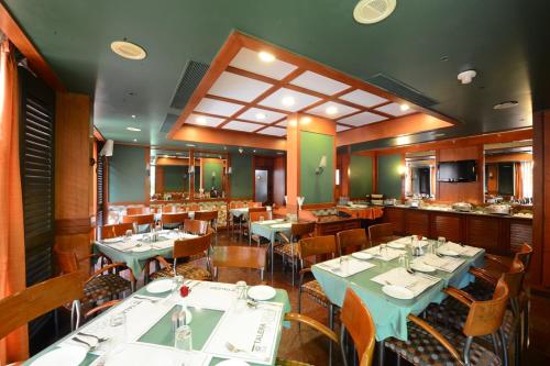a dining room with tables and chairs in a restaurant at Trance Oakwood Hotel in Pune
