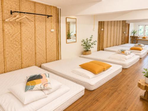 three large beds in a room with wooden floors at Ping Dara Pool Villa Party in Ban San Pa Sak