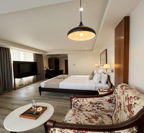 a hotel room with a bed and a couch at Comfort Hotel Kishore Azamgarh in Āzamgarh
