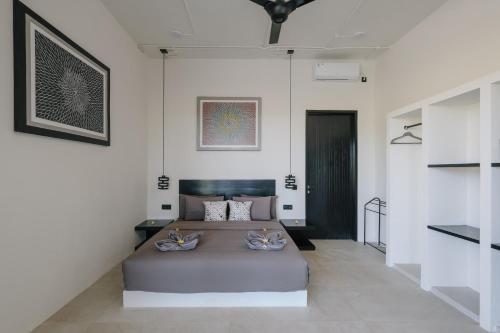 a bedroom with a large bed in a white room at Tris Villas ocean view in Kuta Lombok