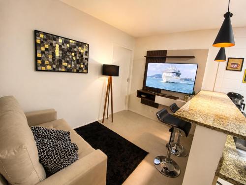 a living room with a couch and a flat screen tv at Charmoso apartamento na Lapa in Rio de Janeiro