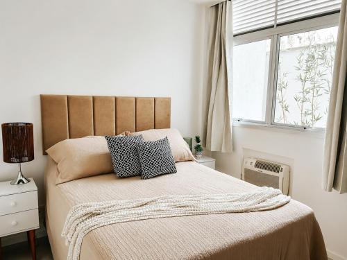 a bedroom with a bed with two pillows on it at Charmoso apartamento na Lapa in Rio de Janeiro
