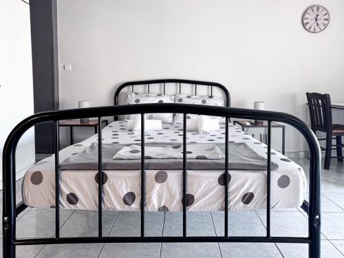 ein Metallbett in einem Schlafzimmer mit einer Uhr an der Wand in der Unterkunft Martheo Studios 2 in Mytilini