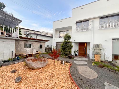 a house with a garden in front of it at BRICKS and BLOCKS MIYOTA in Miyota