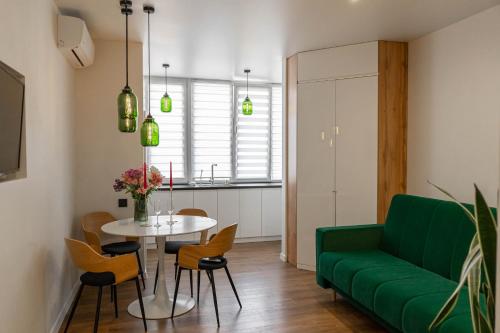 a living room with a green couch and a table at Apartment 5 star CENTER in Vinnytsya