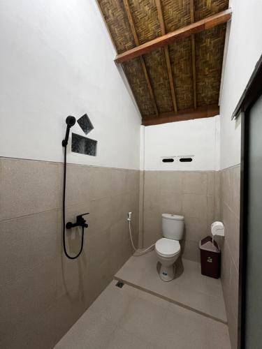 a bathroom with a shower and a toilet at PANORAMA BUNGALOWs in Tetebatu