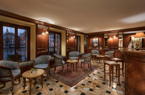 a bar with chairs and tables in a room at Sina Palazzo Sant'Angelo in Venice