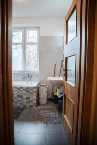 a bathroom with a tub and a sink at Apartmány Ve Mlejně in Čachrov