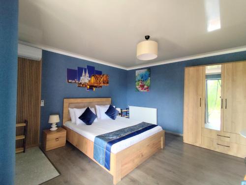 a bedroom with a large bed with blue walls at Haus Georg in Zugdidi
