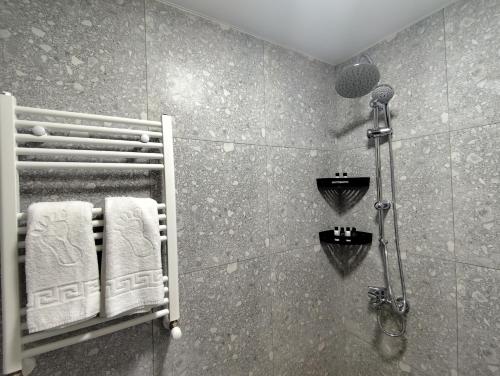 a bathroom with a shower and towels on a wall at Haus Georg in Zugdidi