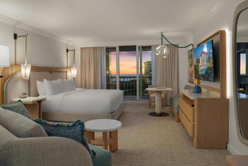 a hotel room with a bed and a couch at Naples Grande Beach Resort in Naples