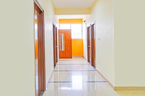 an empty hallway with doors and a tile floor at Hotel O JK Blue Rock Comforts in Bangalore