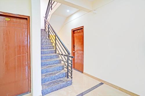 a stairway with blue stairs and a wooden door at Hotel O JK Blue Rock Comforts in Bangalore