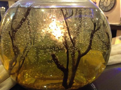 a glass vase with a tree in it on a table at ''EPAVLIS boutique GALAXIDI'' in Galaxidhion