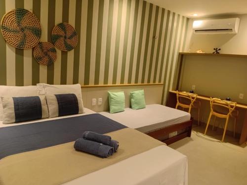 a hotel room with two beds and a table at AMARE Condomínio ap 103 in Barra Grande