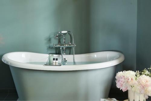 a white bath tub with a faucet in a bathroom at Domaine de Chalamon - Fontenille Collection in Saint-Rémy-de-Provence