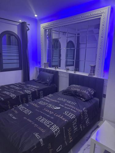 two beds in a room with purple lights at Maha Beach Cabo Negro Duplex 6 person restyled and renovated 2026 in Cabo Negro
