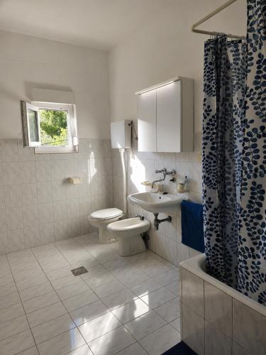 a bathroom with a toilet and a sink at Rooms LuaMar in Sali