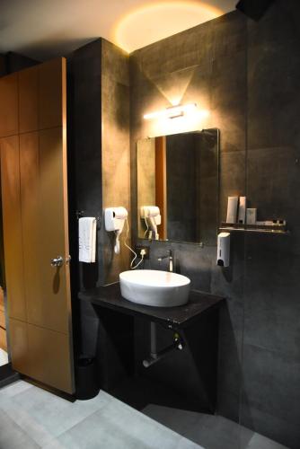 a bathroom with a sink and a mirror at Chitra's City Side Resort in Solapur