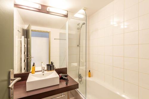 a white bathroom with a sink and a shower at Les Charmes C15 - Le Val Joly in Eppe-Sauvage