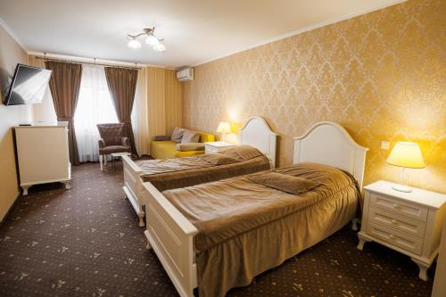 a hotel room with two beds and a couch at City Center Residence in Chernivtsi