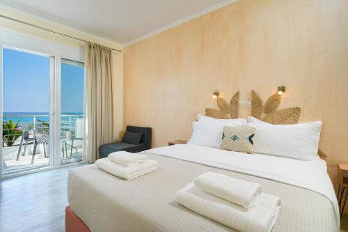 a bedroom with a large bed with a view of the ocean at OzioMari Suites in Limenaria