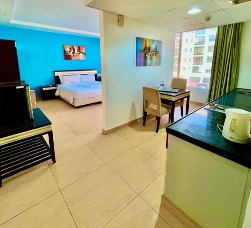 a room with a bed and a room with a desk at Saffron Hotel and Lounges in Muscat