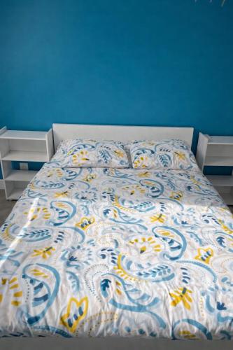 a bed in a bedroom with a blue wall at Chambre privée proche centre ville in Caen