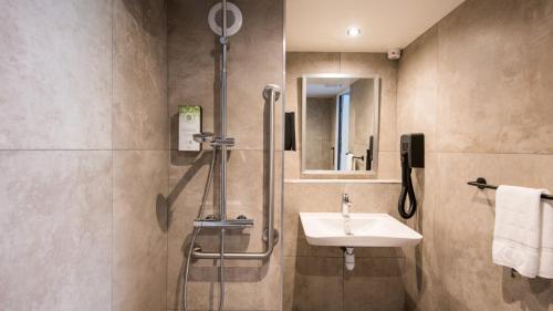 a bathroom with a sink and a shower at Campanile NATURE - Brive-la-Gaillarde in Brive-la-Gaillarde