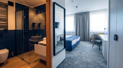 a hotel room with a bed and a bathroom at Hotel Szydłowski in Gdańsk