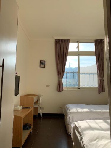 a hotel room with two beds and a window at 富喜民宿二館 in Nangan
